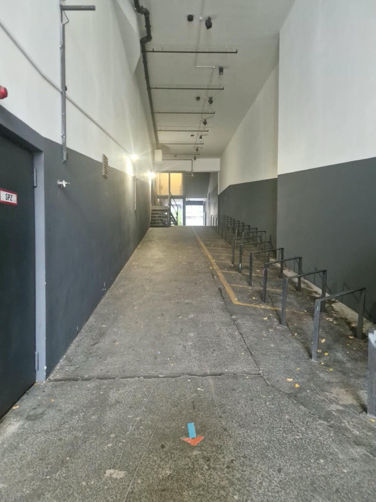 The ramp from its lowest point: a wide concrete floor rising straight towards the street, with bicycle racks on the right.