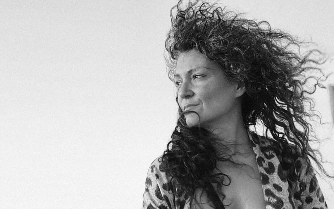 Katerina Dimopoulou, curly hair blowing in the wind.