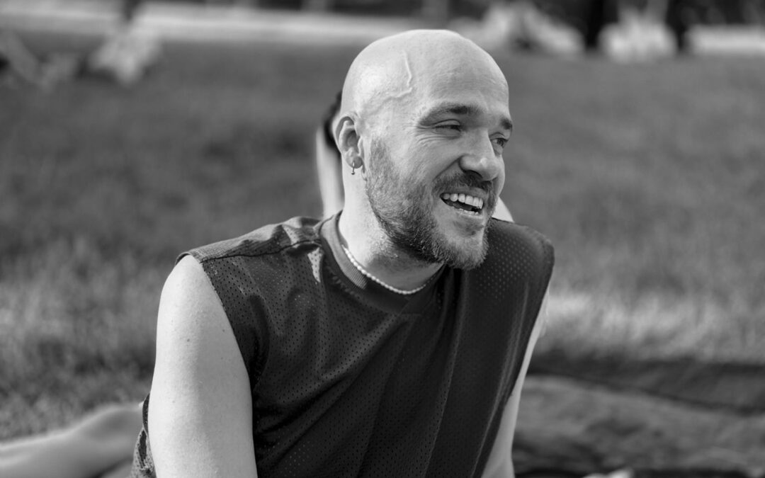 Konstantinos Alexis laughing, at a picnic in a park.