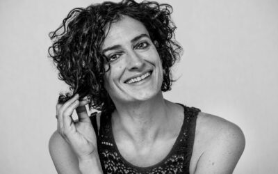 Στέλλα Ζάννου χαμογελά, παίζοντας με μια μπούκλα.