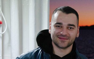 Ηλίας Παπαγιάννης χαμογελά, με δερμάτινο μπουφάν.